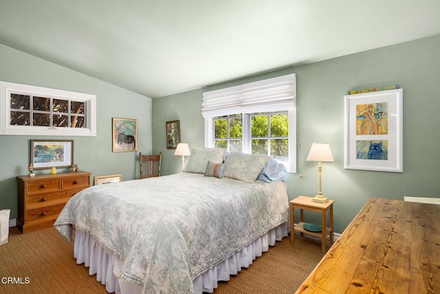 carpeted bedroom featuring baseboards and lofted ceiling