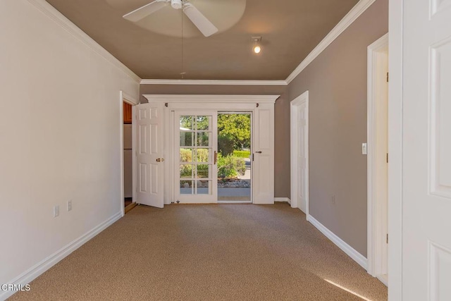 empty room featuring a ceiling fan, carpet, baseboards, and ornamental molding