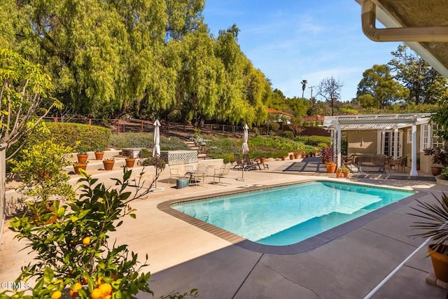 outdoor pool with a patio area, fence, and a pergola