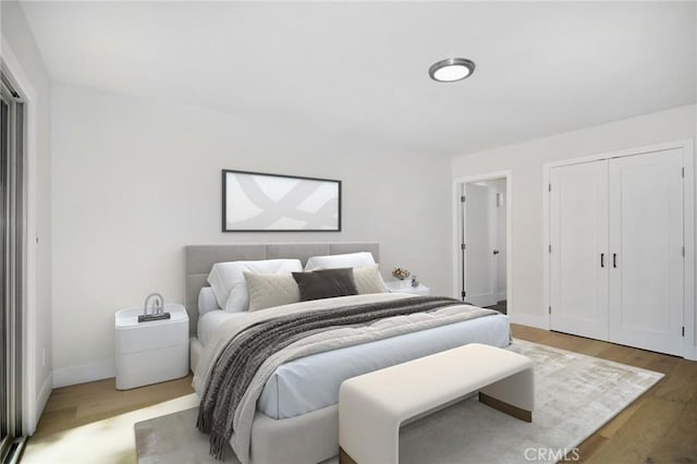 bedroom with light wood-style flooring and baseboards