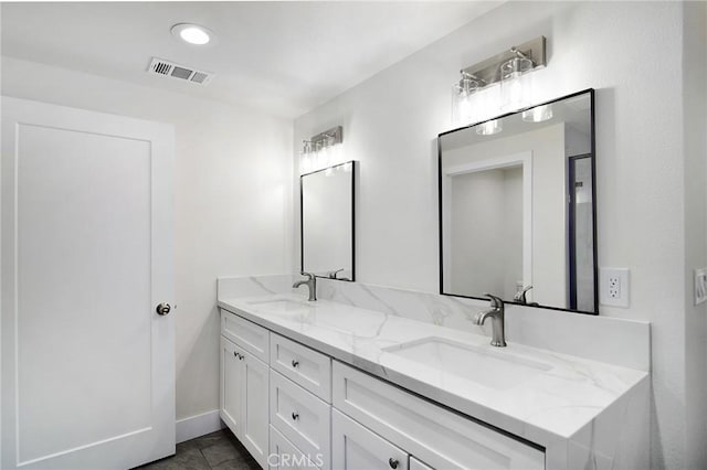 full bath with visible vents, a sink, baseboards, and double vanity