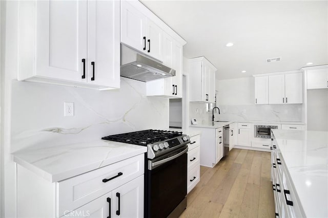 kitchen with stainless steel appliances, white cabinets, visible vents, and under cabinet range hood