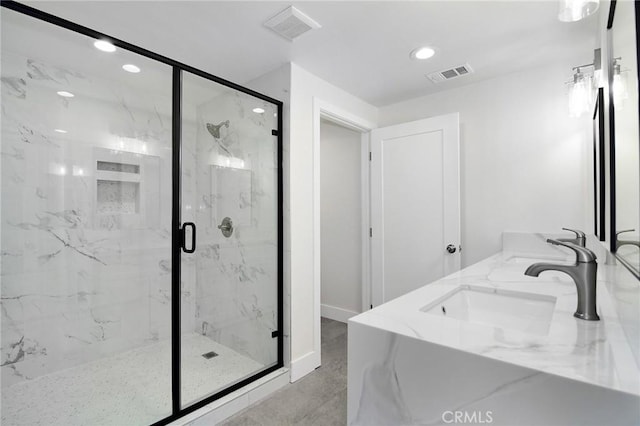 full bath with a marble finish shower, visible vents, a sink, and recessed lighting