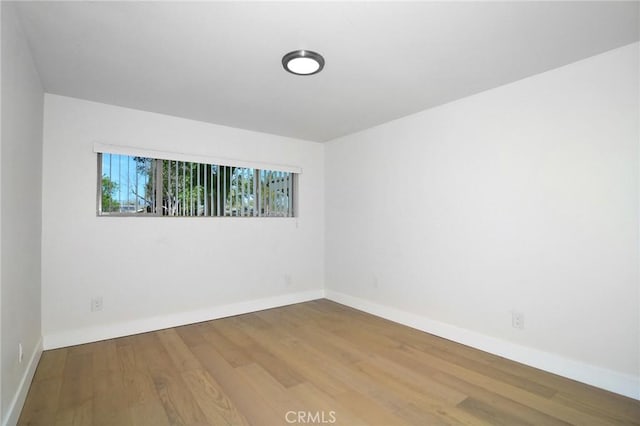 spare room with wood finished floors and baseboards