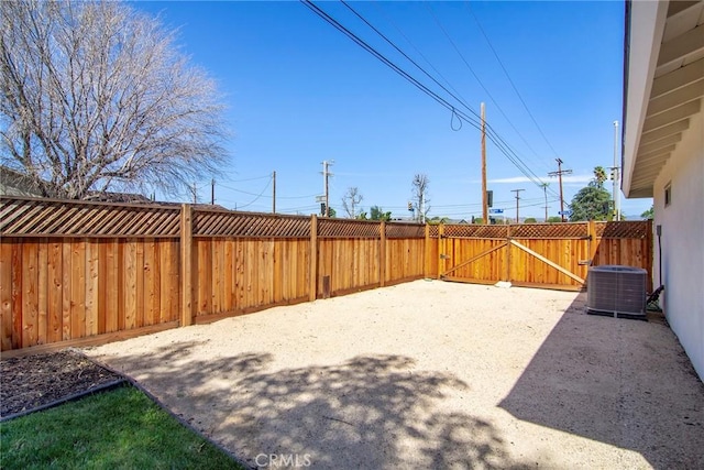 view of yard featuring central air condition unit, a gate, fence, and a patio