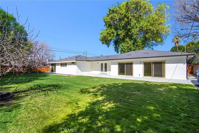 back of property with a yard, a fenced backyard, a patio, and stucco siding