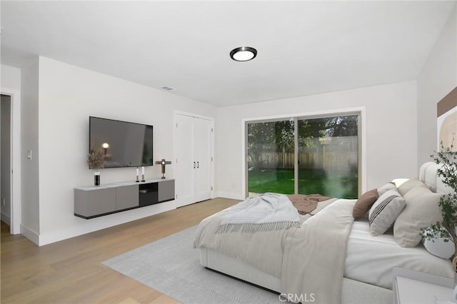 bedroom featuring access to outside, wood finished floors, and baseboards