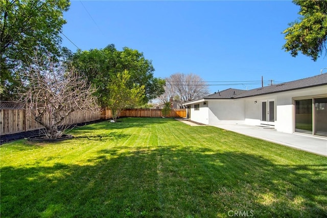 view of yard with a patio area, a fenced backyard, and french doors