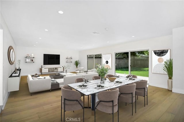 dining area with light wood-type flooring, visible vents, and recessed lighting