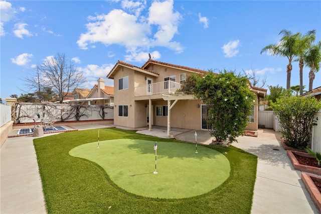 40115 Starling St, Temecula, CA 92591 - back of property featuring a putting green, a patio area, a balcony, stucco siding, and a fenced backyard