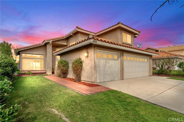 mediterranean / spanish-style home with driveway, a tiled roof, an attached garage, a front yard, and stucco siding