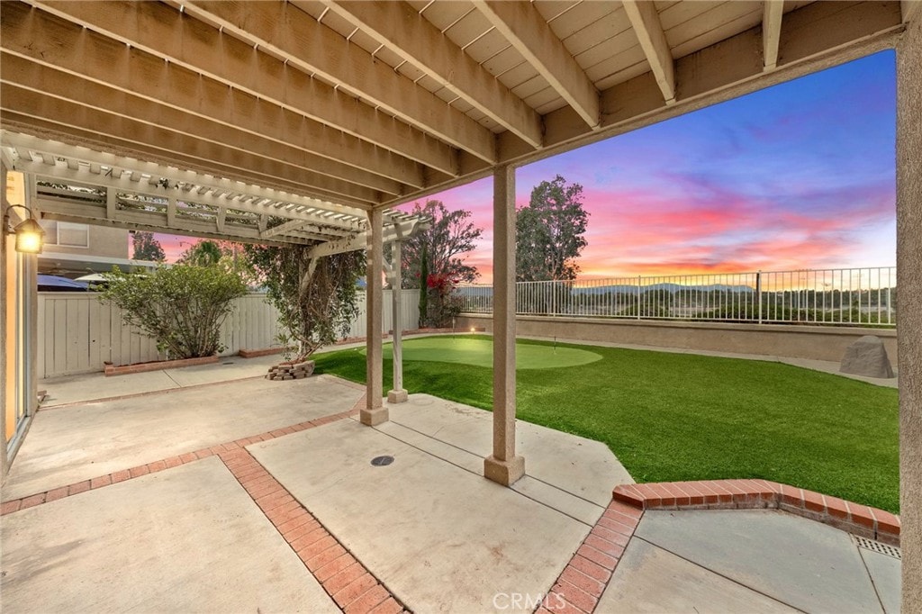 40115 Starling St, Temecula, CA 92591 - patio terrace at dusk with a patio, a pergola, and an area to practice putting