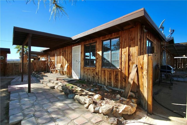 view of side of home featuring a patio area and fence