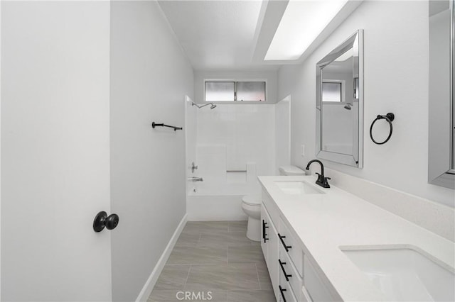 bathroom with toilet, double vanity, washtub / shower combination, and a sink