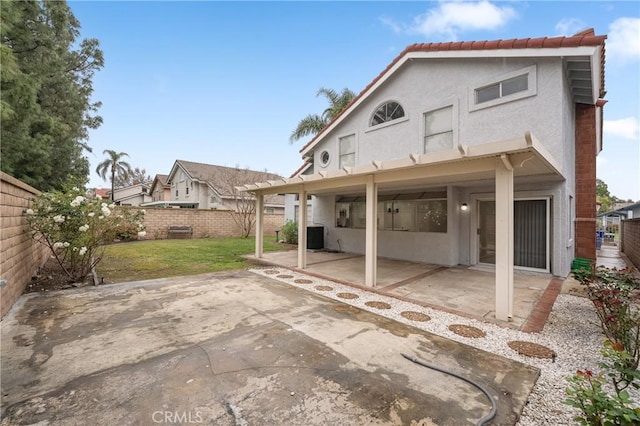 back of property featuring a patio area, a yard, a fenced backyard, and stucco siding