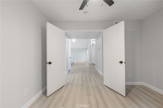 hallway with baseboards and light wood-style floors