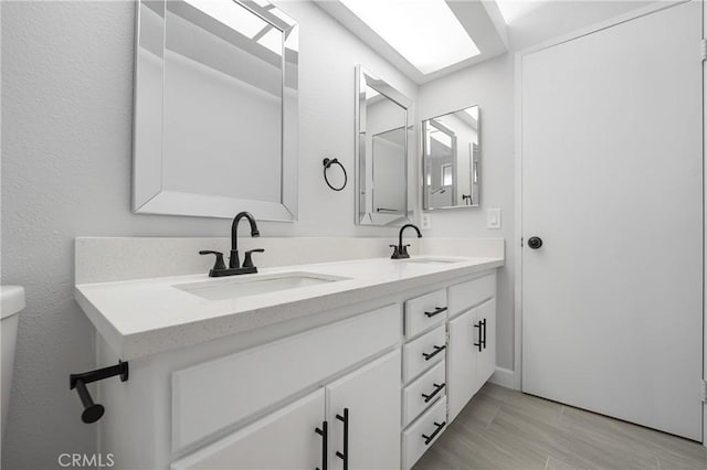 full bathroom featuring wood finished floors, a sink, and double vanity