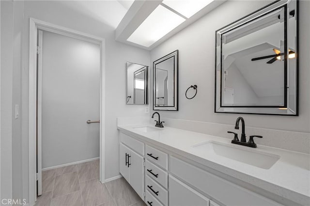 bathroom featuring a sink, baseboards, and double vanity