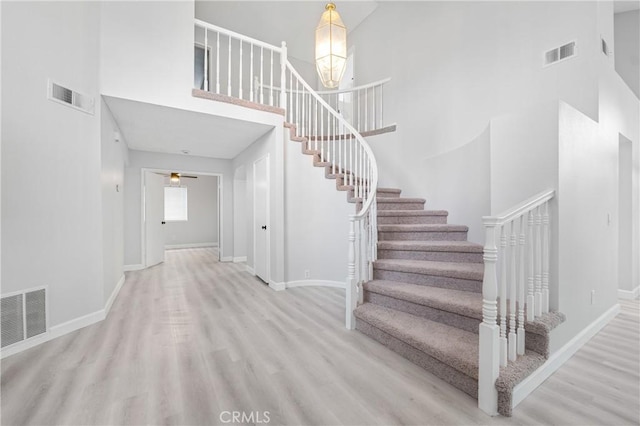 staircase featuring visible vents, baseboards, and wood finished floors