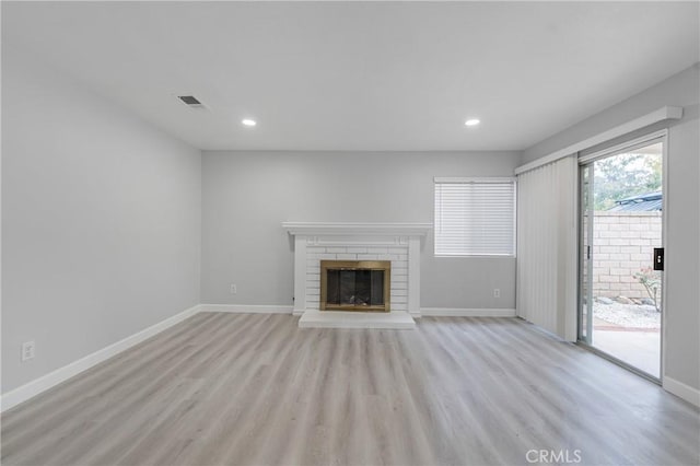 unfurnished living room with a fireplace, recessed lighting, visible vents, light wood-type flooring, and baseboards