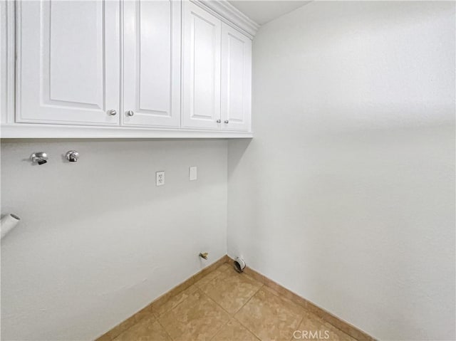 washroom featuring gas dryer hookup, cabinet space, light tile patterned floors, and hookup for a washing machine