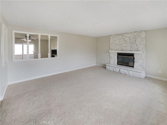 unfurnished living room with a textured ceiling, a fireplace, baseboards, and carpet flooring