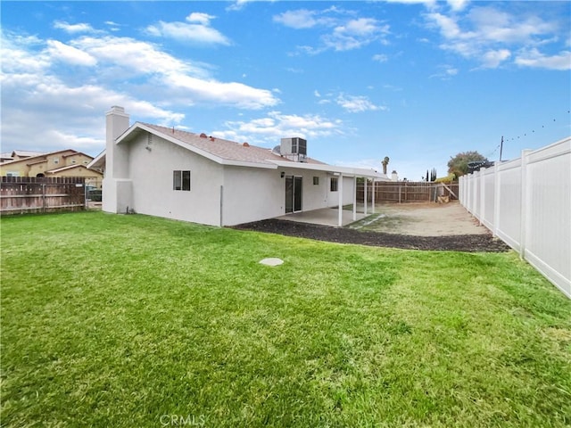 rear view of property with a patio, cooling unit, a fenced backyard, a yard, and stucco siding