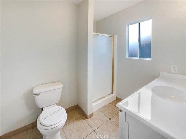 bathroom with toilet, a shower stall, vanity, baseboards, and tile patterned floors