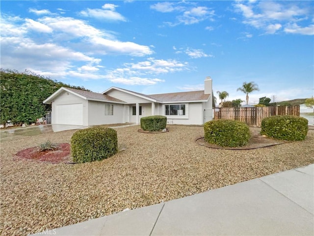 ranch-style house featuring a garage, driveway, and fence