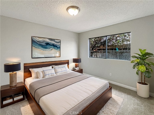 carpeted bedroom with a textured ceiling and baseboards