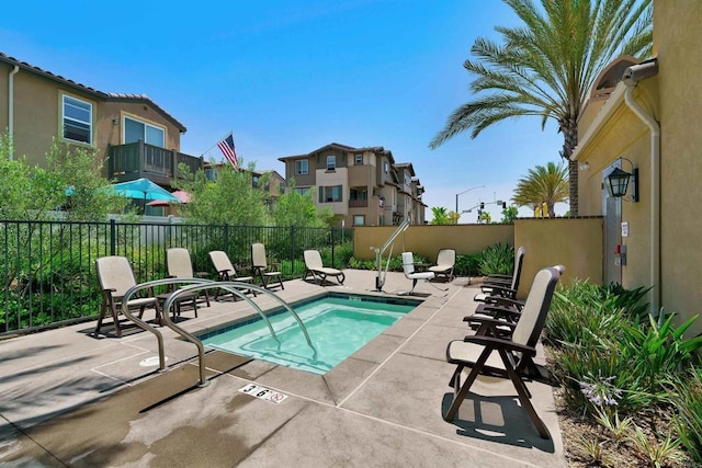 view of pool featuring a community hot tub, a patio area, and fence private yard