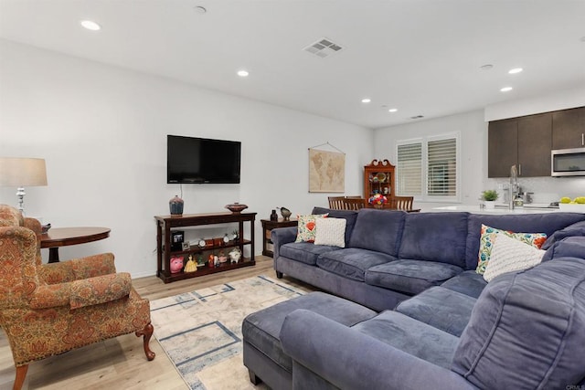 living room featuring recessed lighting, visible vents, and light wood finished floors