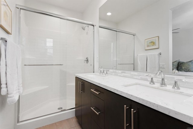 full bathroom featuring double vanity, a sink, and a shower stall