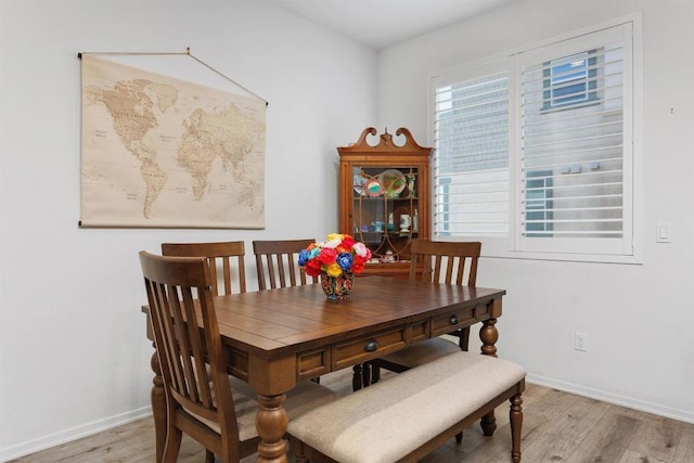 dining area with light wood-style flooring and baseboards