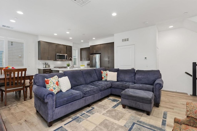 living area featuring light wood finished floors, visible vents, and recessed lighting