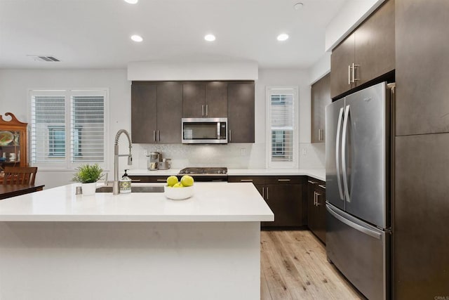 kitchen featuring visible vents, appliances with stainless steel finishes, light countertops, light wood-type flooring, and a sink