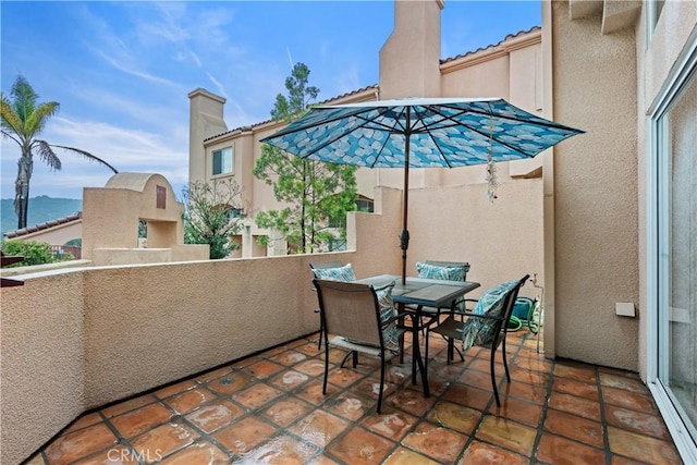 view of patio with outdoor dining space and a balcony