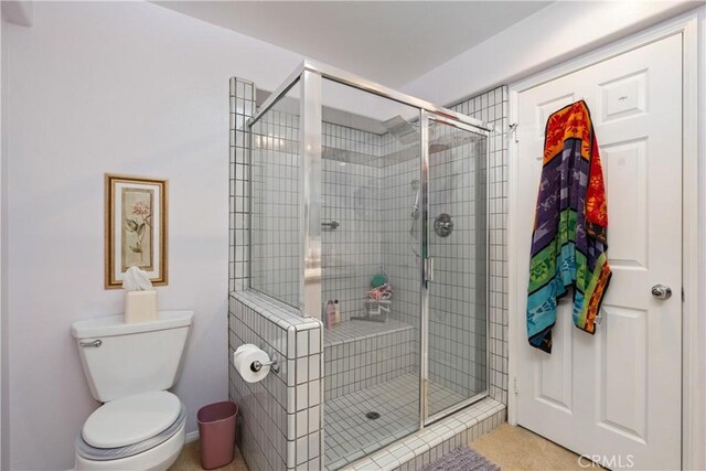 full bathroom with toilet and a shower stall