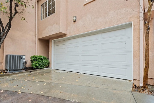 garage featuring cooling unit and concrete driveway