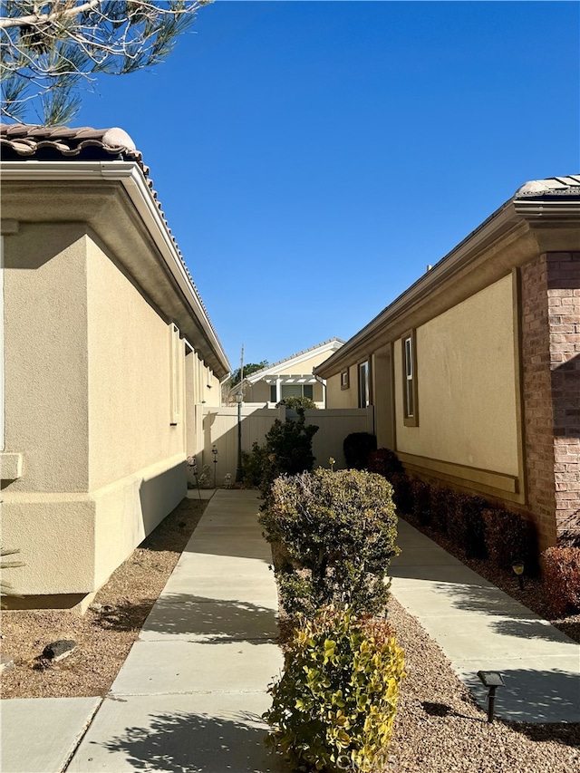 view of home's exterior with fence and stucco siding