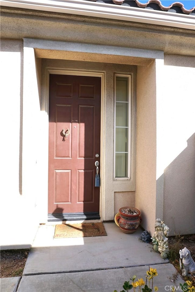 property entrance with stucco siding