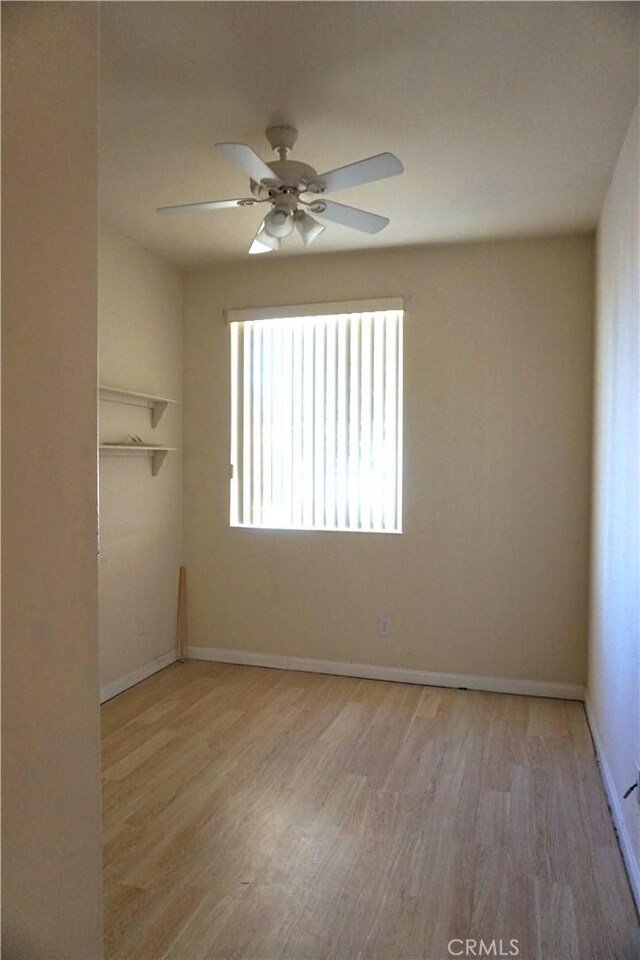 unfurnished room with ceiling fan, baseboards, and wood finished floors