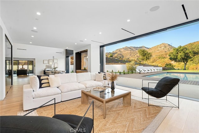 living area with recessed lighting, a mountain view, and wood finished floors