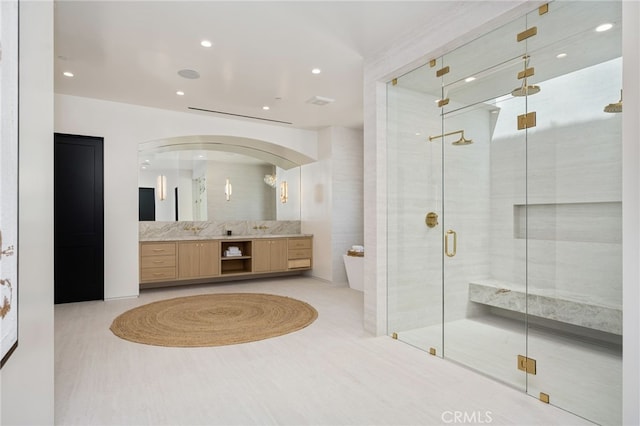 bathroom featuring a stall shower, recessed lighting, and vanity