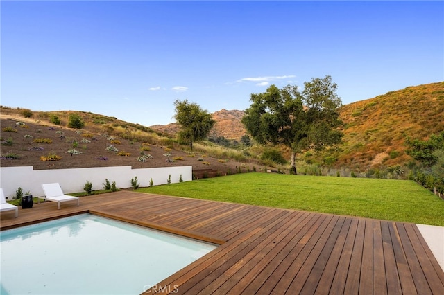 wooden deck with a yard and a mountain view