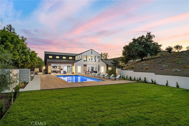 rear view of house featuring a fenced in pool, a yard, fence, and a patio