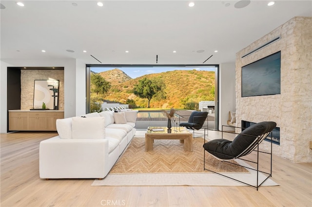 living area featuring light wood-type flooring, plenty of natural light, and recessed lighting