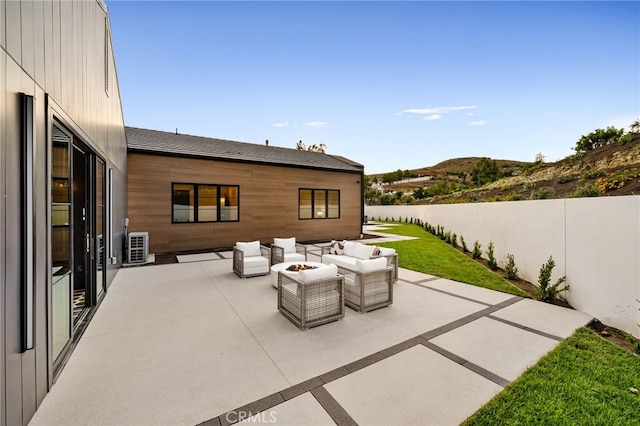 view of patio featuring fence, a mountain view, and an outdoor living space with a fire pit