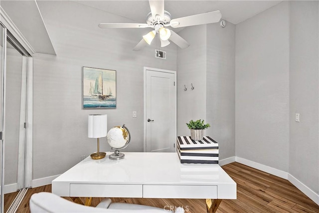 office area featuring a ceiling fan, wood finished floors, visible vents, and baseboards