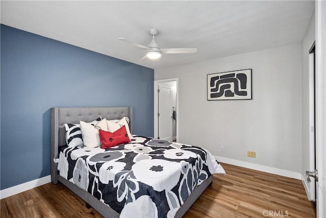 bedroom featuring ceiling fan, baseboards, and wood finished floors